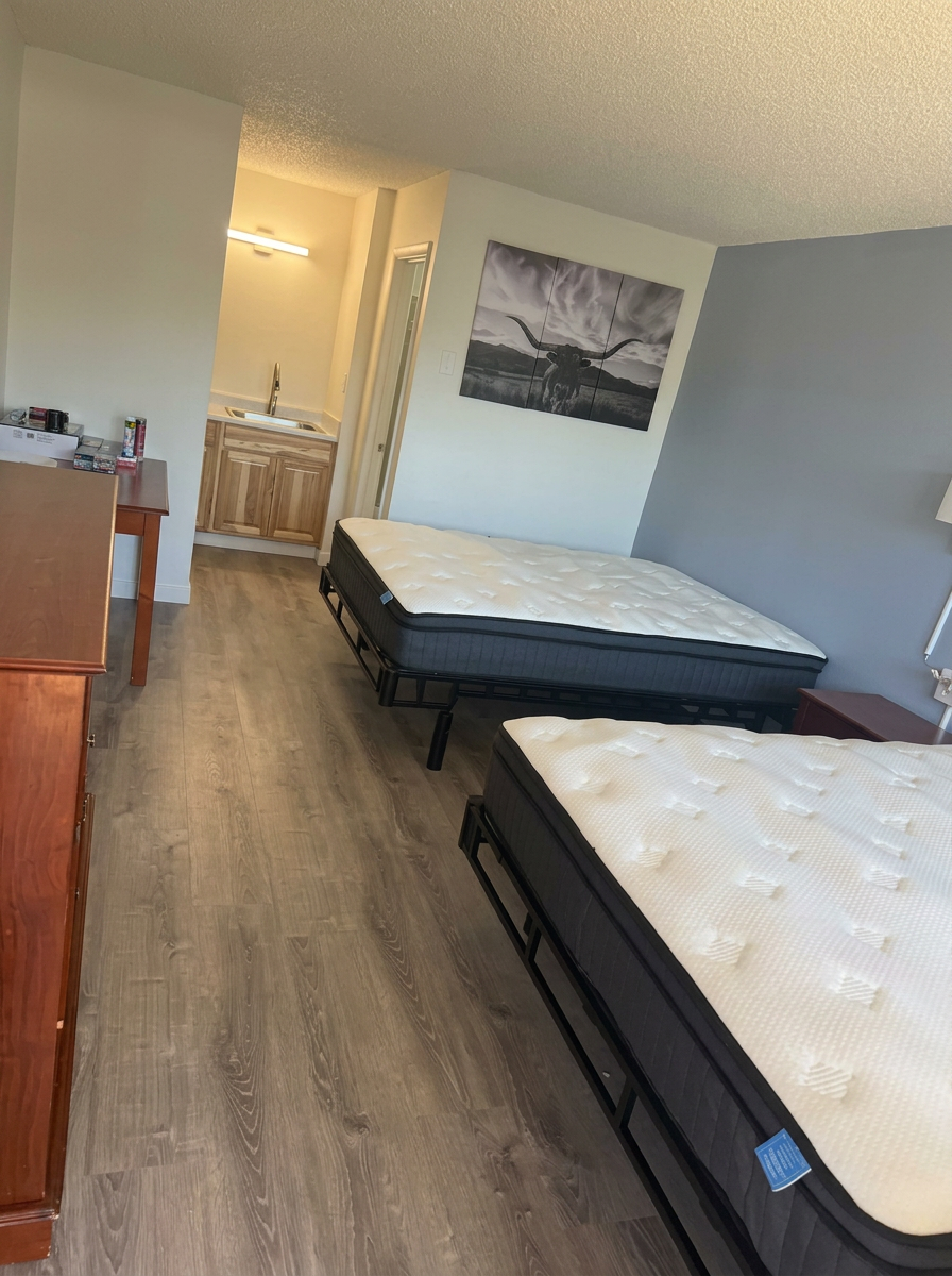 Renovated room with new wood-look flooring, fresh paint and new beds
